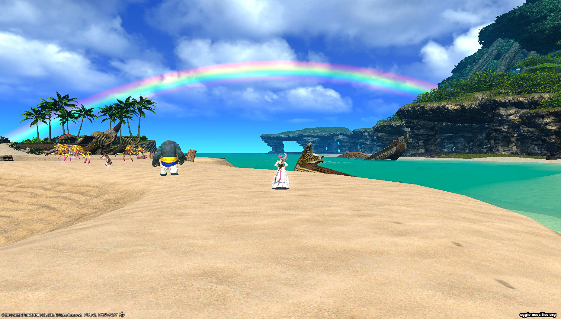 Zel standing on the beach on Aloalo, admiring a rainbow.