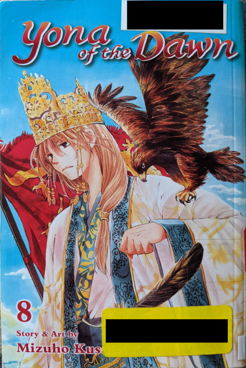 Cover for Yona of the Dawn Volume 8. Suwon is standing in royal regalia with a crown, with a red war banner behind him. His left arm is raised chest high, and a hawk is flying beside him, looking as though it is going to perch.