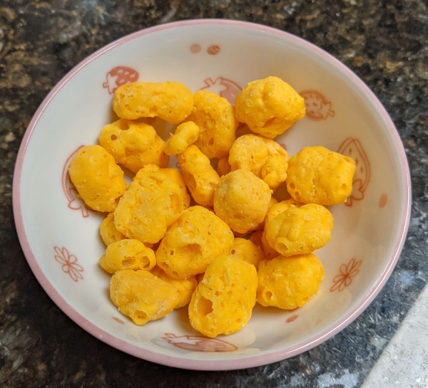 A small bowl containing a one ounce serving of cheddar moon cheese